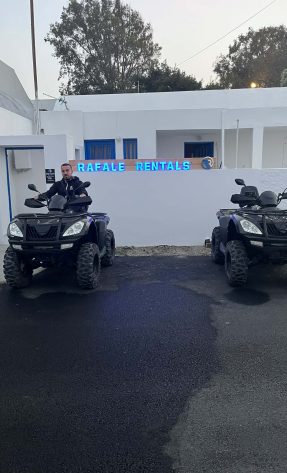 Two black ATVs with a customer riding in Santorini