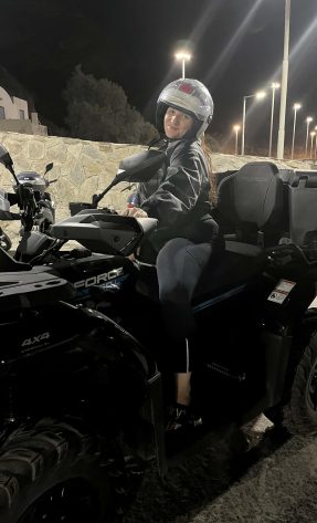 Happy woman riding an ATV in Santorini